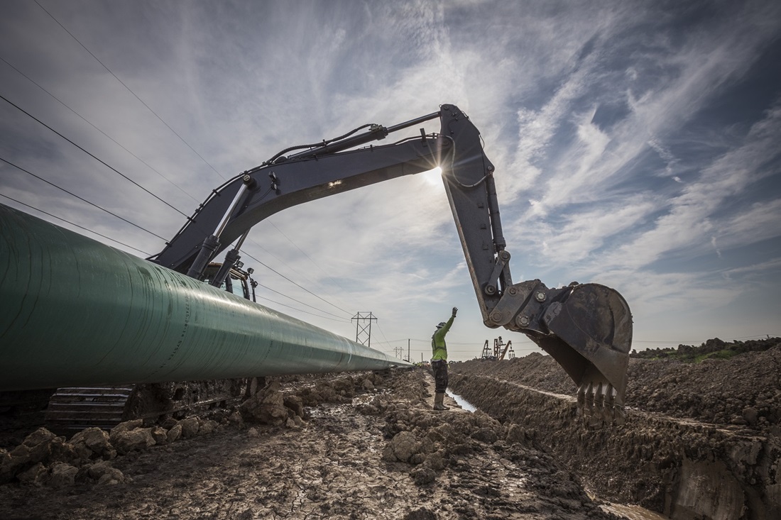 pipeline worker and excavator on right of way