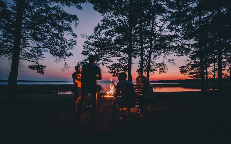 people sitting around campfire